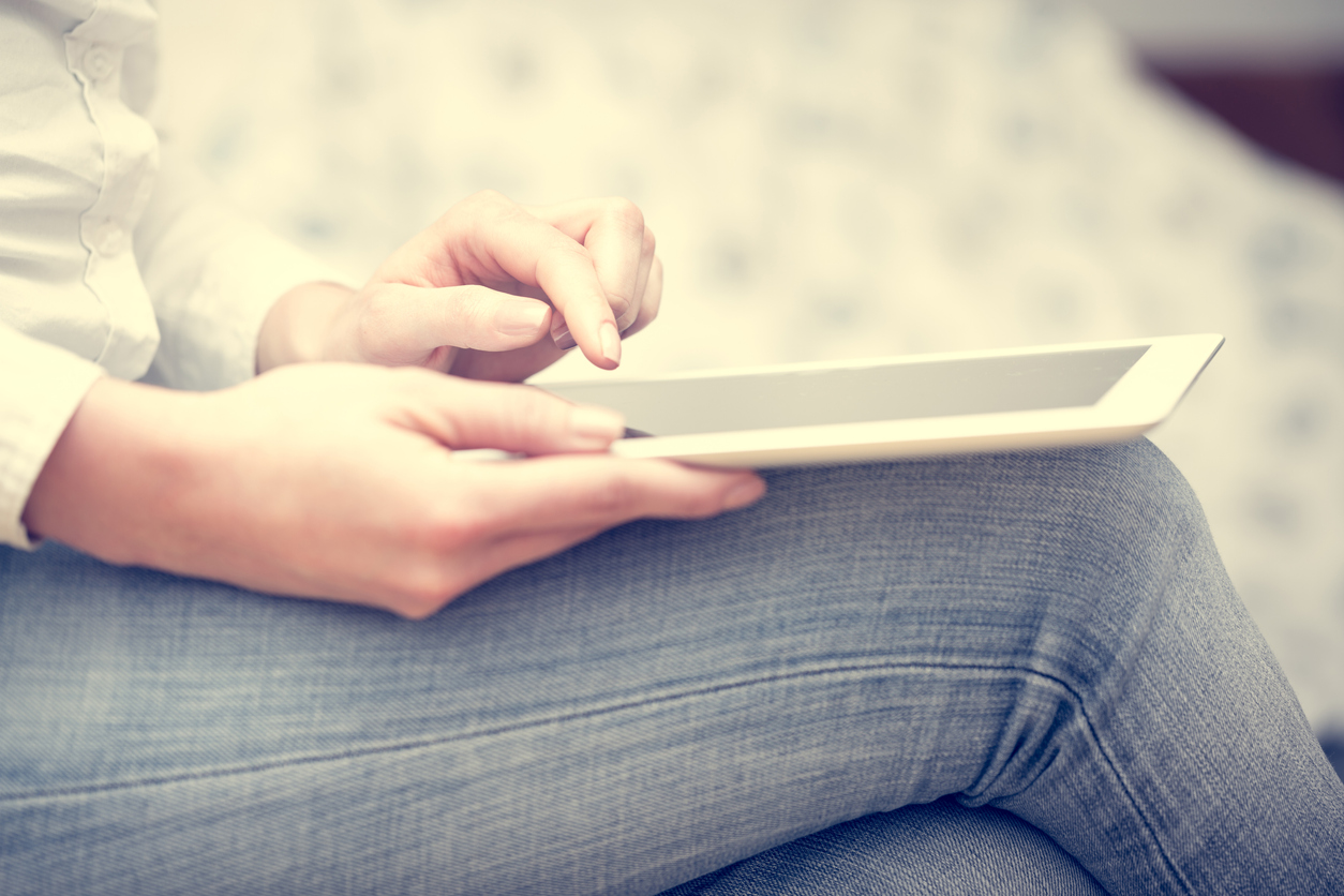 digital detox, Woman in jeans pants uses a tablet.