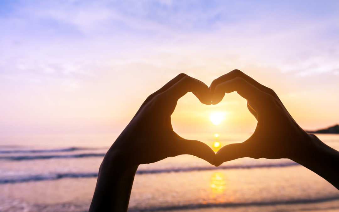 Heart shape, beach and sunset, symbol of romantic travels, love